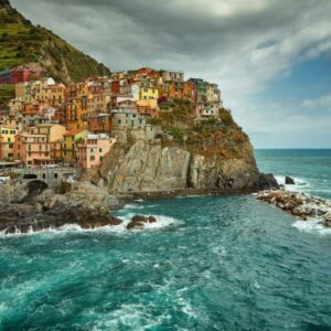 Farverige huse bygget i terrasser på klippen ned mod det blå hav i en af de fem byer i Cinque Terre