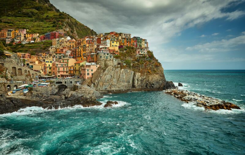 Farverige huse bygget i terrasser på klippen ned mod det blå hav i en af de fem byer i Cinque Terre
